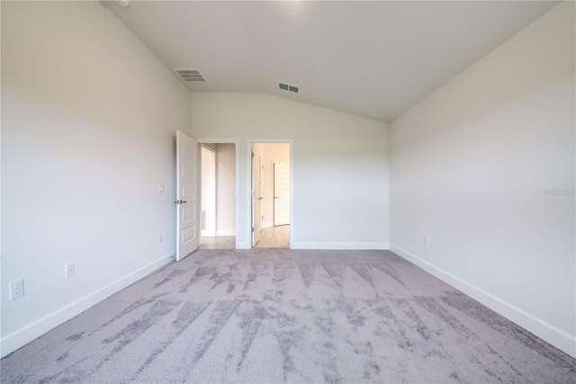 carpeted spare room featuring lofted ceiling