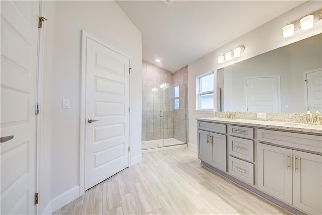 bathroom featuring a shower with door, vanity, lofted ceiling, and hardwood / wood-style flooring