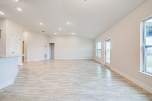 unfurnished living room featuring lofted ceiling and light hardwood / wood-style floors