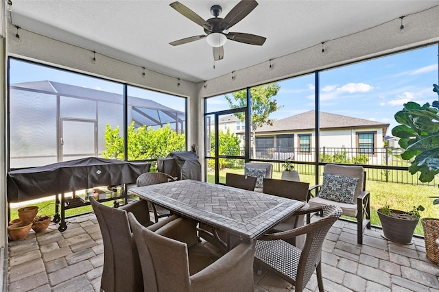 sunroom / solarium featuring ceiling fan