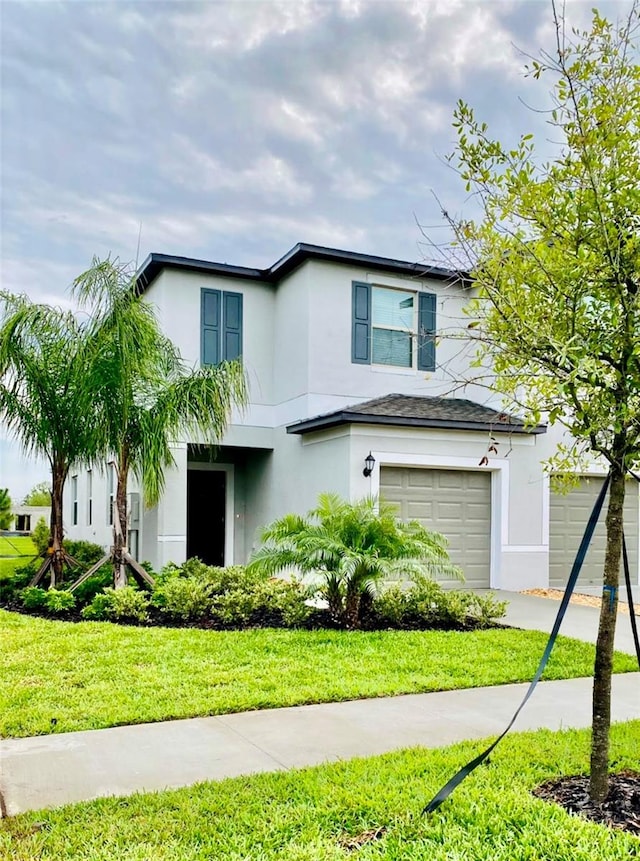 view of property with a front yard and a garage