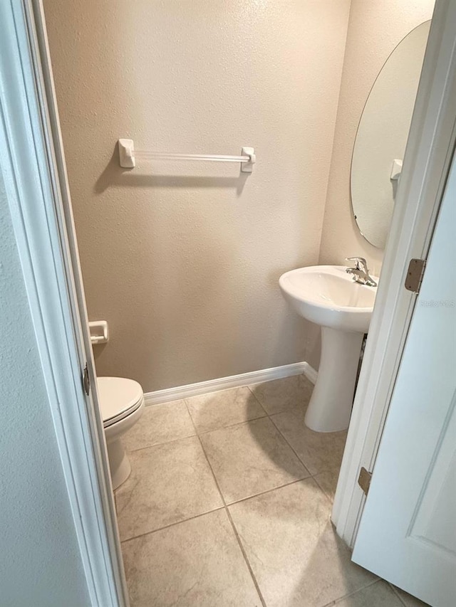 bathroom with toilet and tile patterned flooring