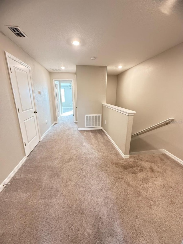 carpeted spare room featuring a textured ceiling