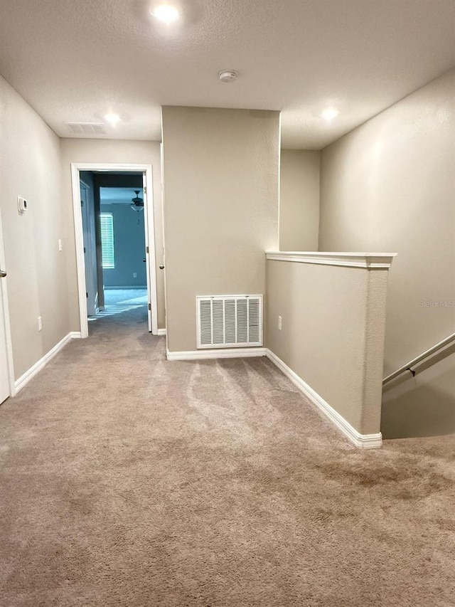 unfurnished room with a textured ceiling and carpet floors