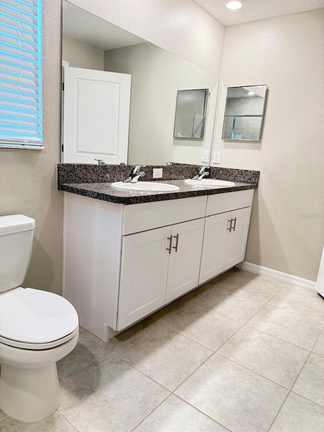 bathroom featuring vanity, toilet, and tile patterned flooring