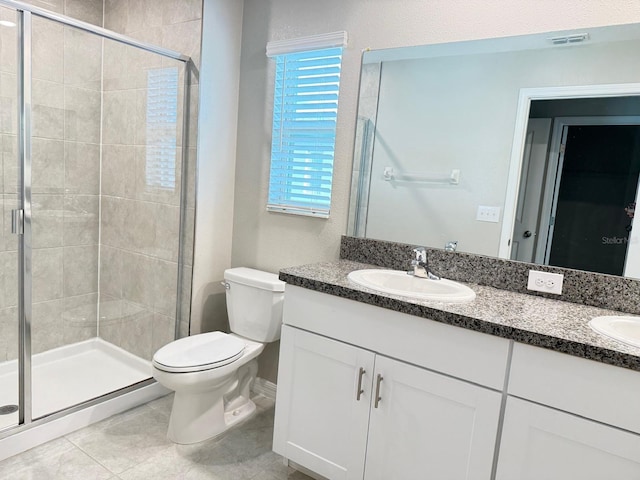 bathroom featuring vanity, toilet, tile patterned flooring, and an enclosed shower