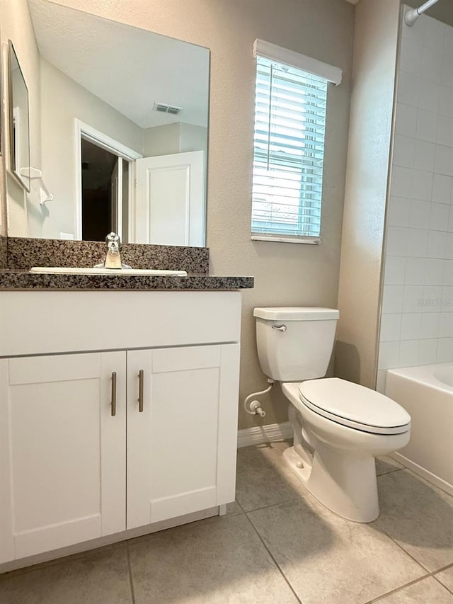 full bathroom with vanity, tiled shower / bath combo, toilet, and tile patterned flooring