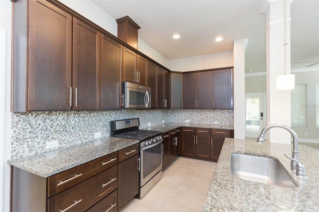 kitchen featuring light tile patterned flooring, stainless steel appliances, backsplash, and light stone counters