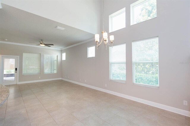 tiled spare room featuring ceiling fan with notable chandelier, crown molding, and a wealth of natural light