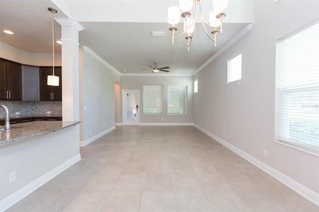 kitchen featuring tasteful backsplash, light tile patterned floors, ceiling fan with notable chandelier, stone countertops, and ornamental molding