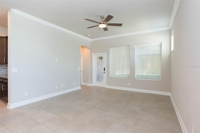 tiled spare room featuring ornamental molding and ceiling fan