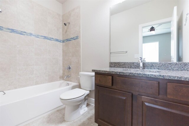 full bathroom featuring tile patterned flooring, tiled shower / bath, toilet, vanity, and ceiling fan