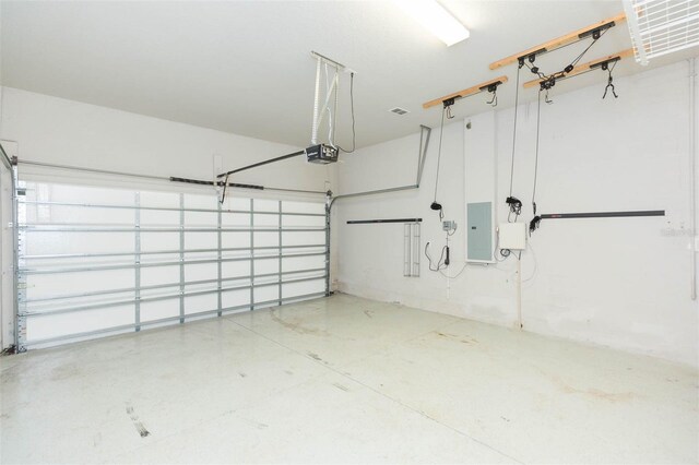 garage with a garage door opener and electric panel