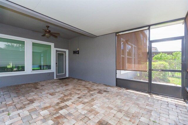 unfurnished sunroom with ceiling fan