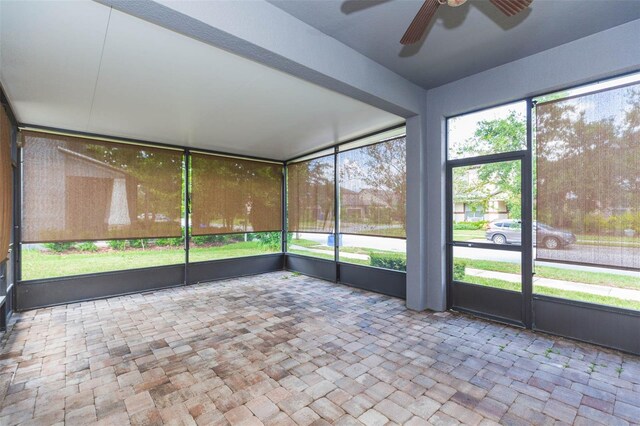 unfurnished sunroom with ceiling fan and a wealth of natural light