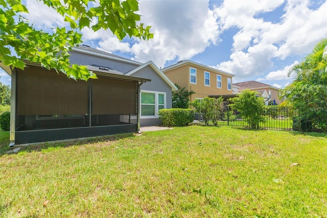 rear view of house with a sunroom and a yard