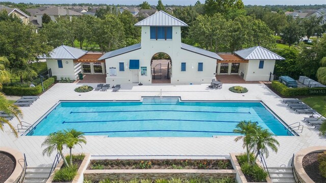 back of house with a patio and a community pool