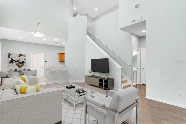 living room with hardwood / wood-style floors and a towering ceiling