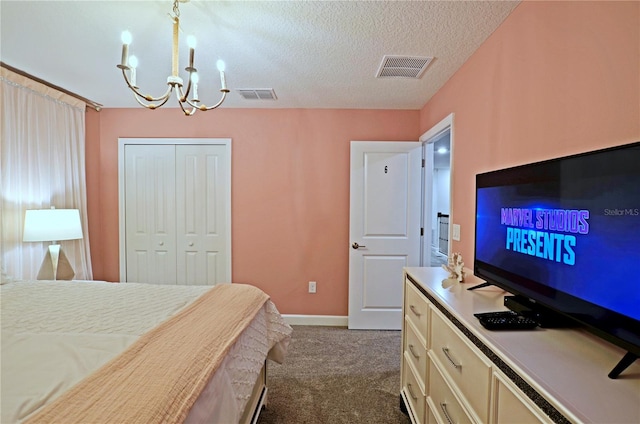 carpeted bedroom with a textured ceiling, a closet, and an inviting chandelier