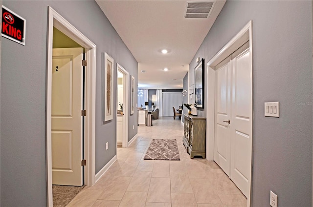 hall featuring light tile patterned floors