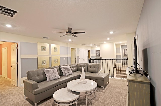 living room with light carpet, a textured ceiling, built in features, and ceiling fan