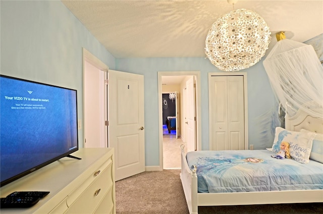 bedroom featuring a textured ceiling, a closet, and light colored carpet