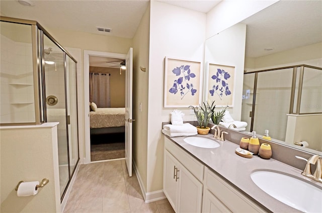 bathroom featuring tile patterned floors, dual vanity, a shower with door, and ceiling fan