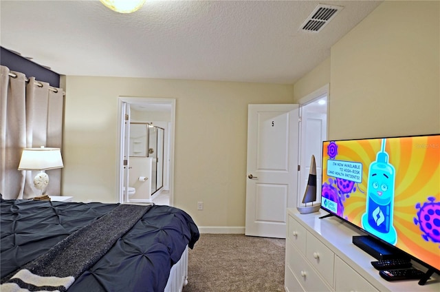 bedroom featuring ensuite bath, a textured ceiling, and light colored carpet