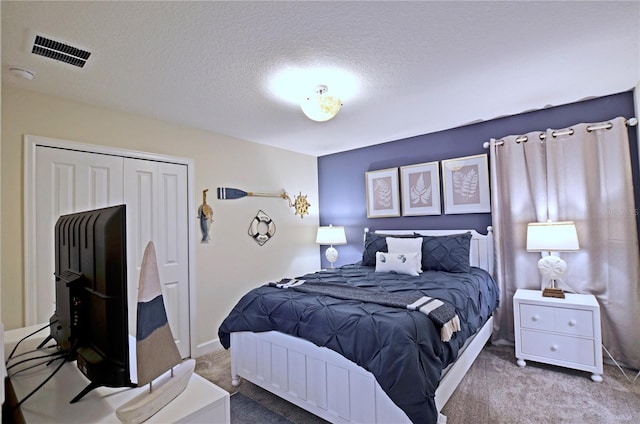 bedroom with carpet flooring, a closet, and a textured ceiling