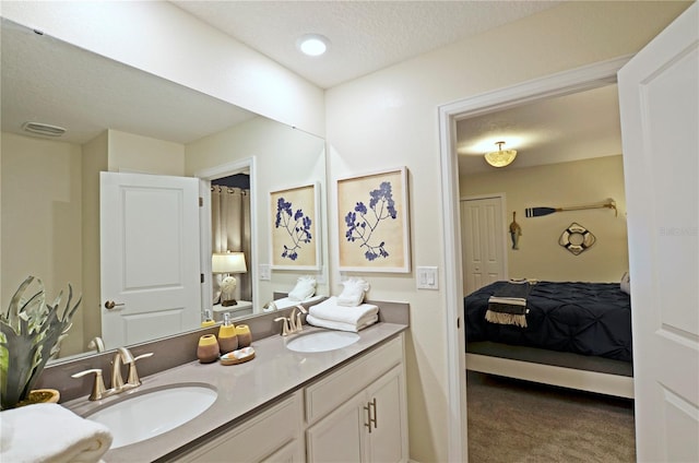 bathroom with a textured ceiling and double vanity