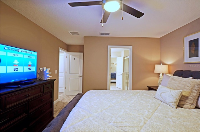 bedroom with ensuite bath, light carpet, and ceiling fan