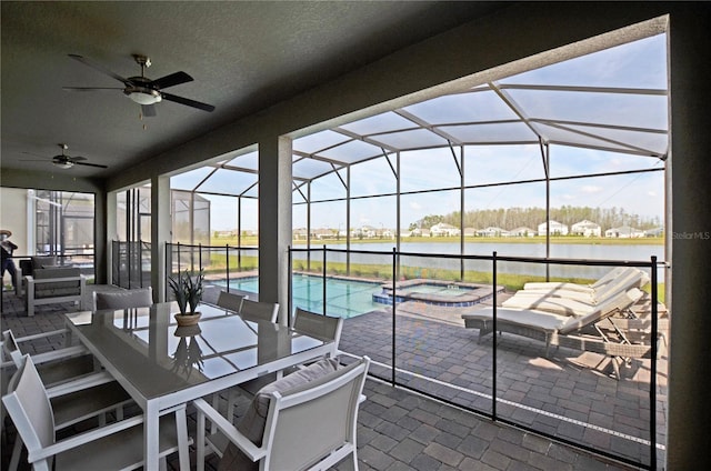 2857 Bookmark Dr, Kissimmee, FL 34746 - view of patio / terrace featuring outdoor dining area, ceiling fan, a water view, a pool with connected hot tub, and glass enclosure