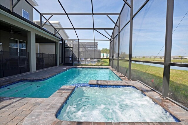 2857 Bookmark Dr, Kissimmee, FL 34746 - view of swimming pool featuring a patio area, glass enclosure, a water view, and a pool with connected hot tub