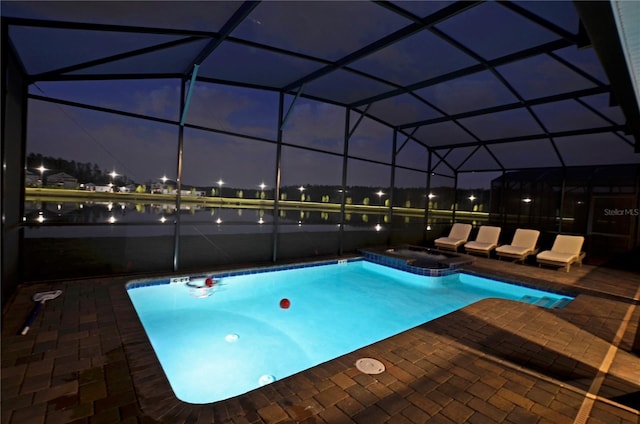 pool at twilight featuring an in ground hot tub, a patio, and glass enclosure