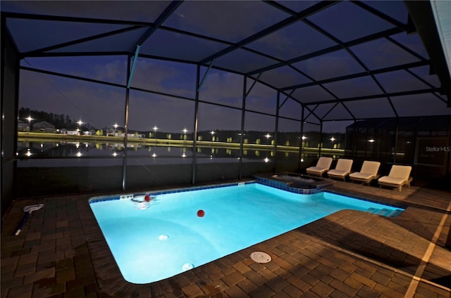 2857 Bookmark Dr, Kissimmee, FL 34746 - pool at night featuring a lanai, a patio, and a pool with connected hot tub