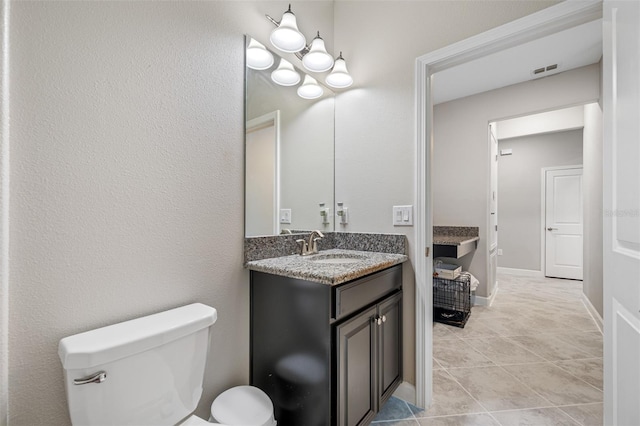 bathroom with vanity, toilet, and tile patterned floors