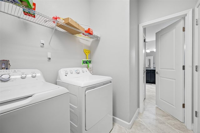 clothes washing area with independent washer and dryer and light tile patterned floors