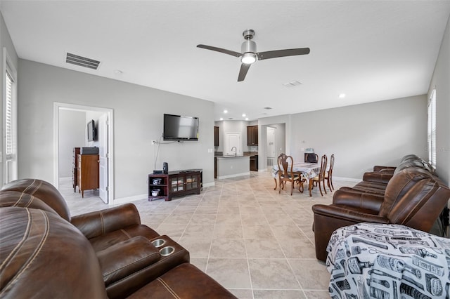 living room with sink, light tile patterned floors, and ceiling fan