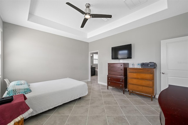 tiled bedroom with a raised ceiling and ceiling fan