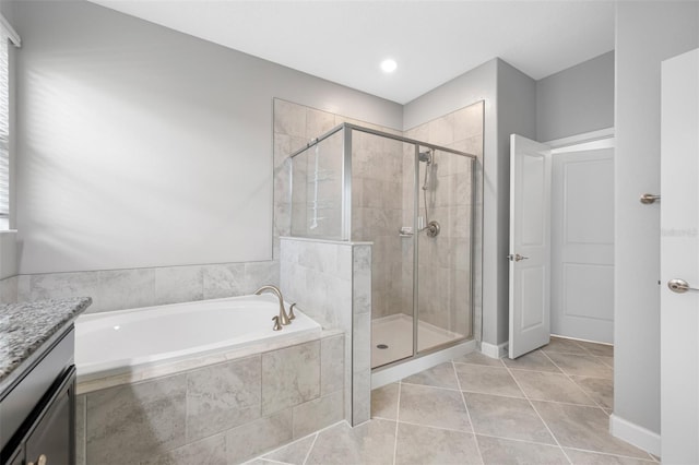 bathroom featuring plus walk in shower, vanity, tile patterned floors, and a wealth of natural light