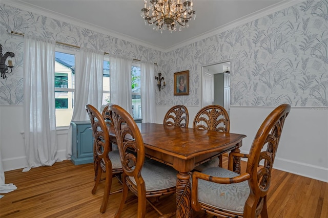 dining space with crown molding, light hardwood / wood-style floors, and a notable chandelier