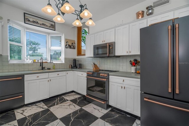 kitchen featuring backsplash, sink, white cabinetry, hanging light fixtures, and high quality appliances