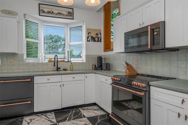 kitchen featuring range with electric stovetop, decorative backsplash, sink, and white cabinetry