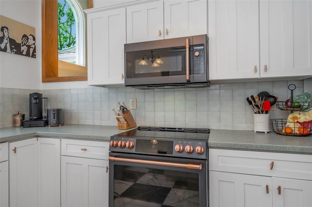 kitchen featuring range with electric stovetop, backsplash, and white cabinetry