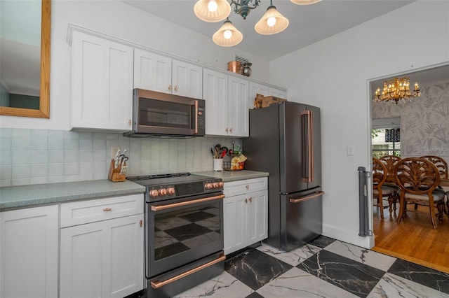 kitchen with decorative light fixtures, white cabinets, and premium appliances