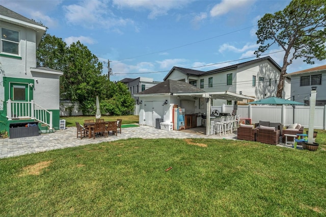 rear view of property featuring exterior bar, a yard, an outdoor living space, and a patio