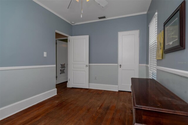 unfurnished bedroom featuring dark wood-type flooring, ceiling fan, and ornamental molding