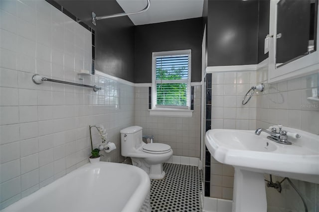 bathroom featuring toilet, tile walls, tile patterned floors, and a washtub