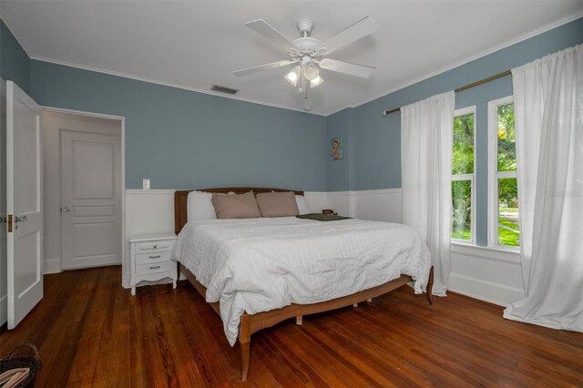 bedroom with dark wood-type flooring, ceiling fan, crown molding, and multiple windows