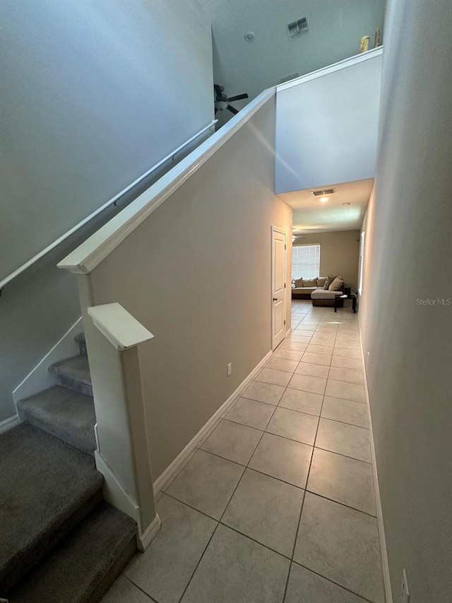 staircase featuring ceiling fan and light tile patterned floors